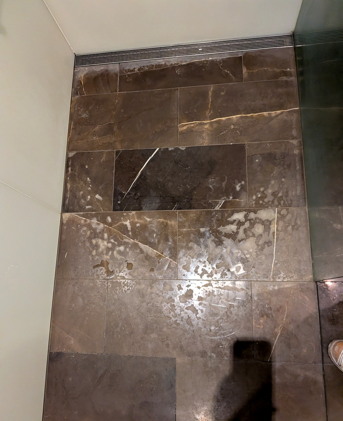 Before — brown stone shower floor stained